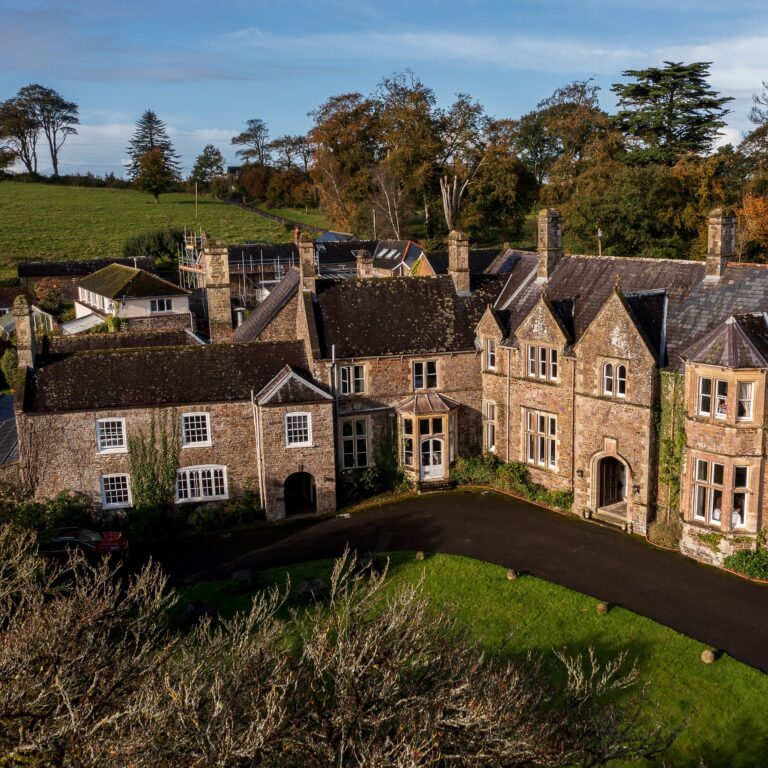 The manor from the air in autumn, with its gables, chimneys and the drive sweeping past the front lawn, Northcote Manor Hotel