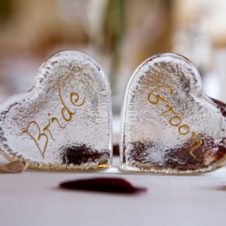 Two glass heart place markers marked Bride and Groom on a white tablecloth, Northcote Manor Hotel