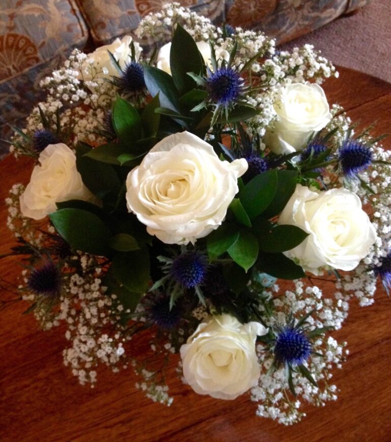 A centrepiece of white roses, gypsophila and blue thistles, Northcote Manor Hotel