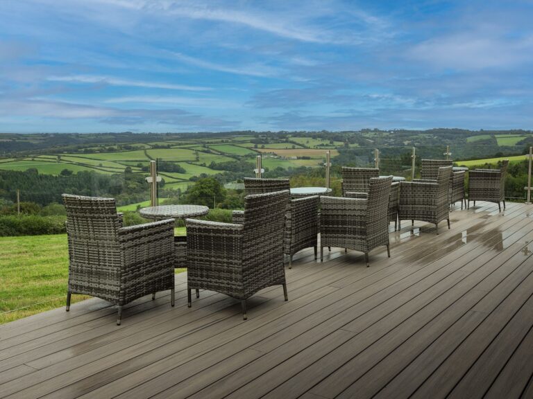 A decked terrace with wicker chairs looking out over fields and hills, Northcote Manor Hotel