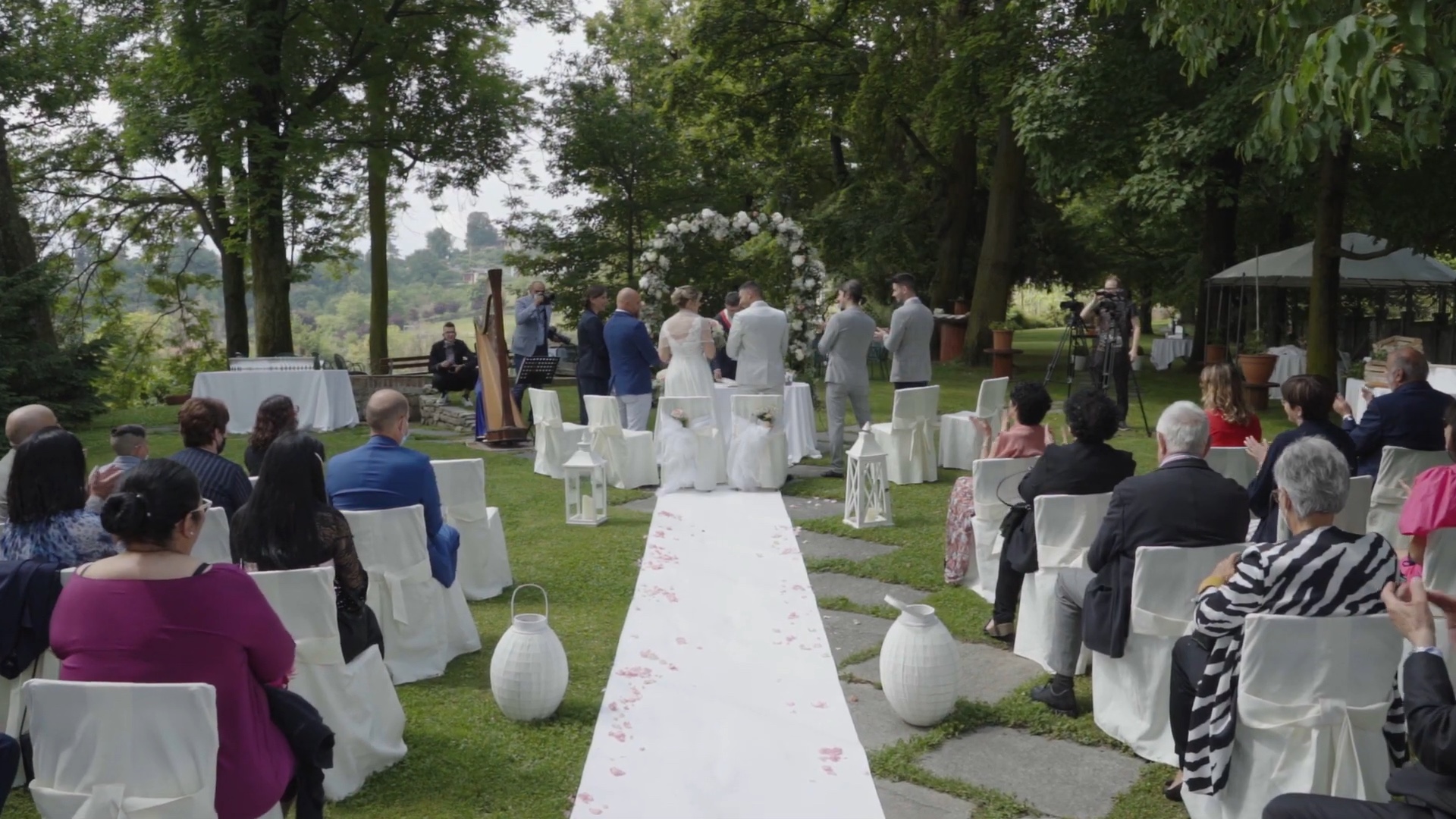 An outdoor ceremony in a garden, white aisle and harpist, from Elisa and Davide's trailer, Nozze da film