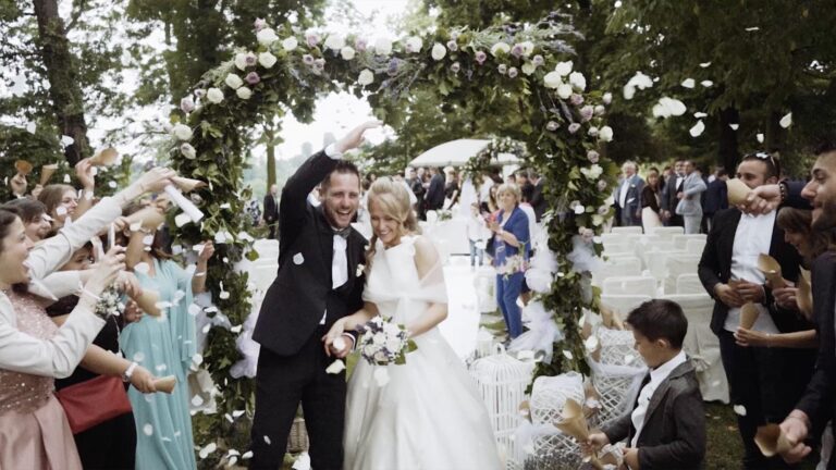 Guests throwing petals as the couple leave an outdoor ceremony under a floral arch, Nozze da film