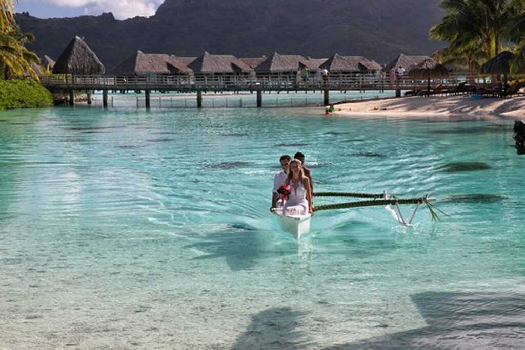 A couple in a canoe by overwater villas, Nunta pe Plaja
