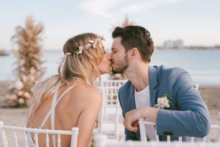A bride and groom kissing at their wedding by the sea, Nunta pe Plaja