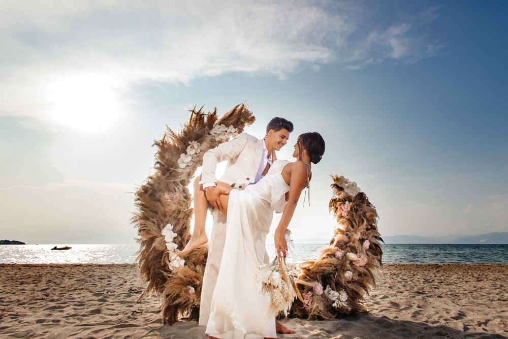 A couple on the beach in front of a dried-flower ring, Nunta pe Plaja