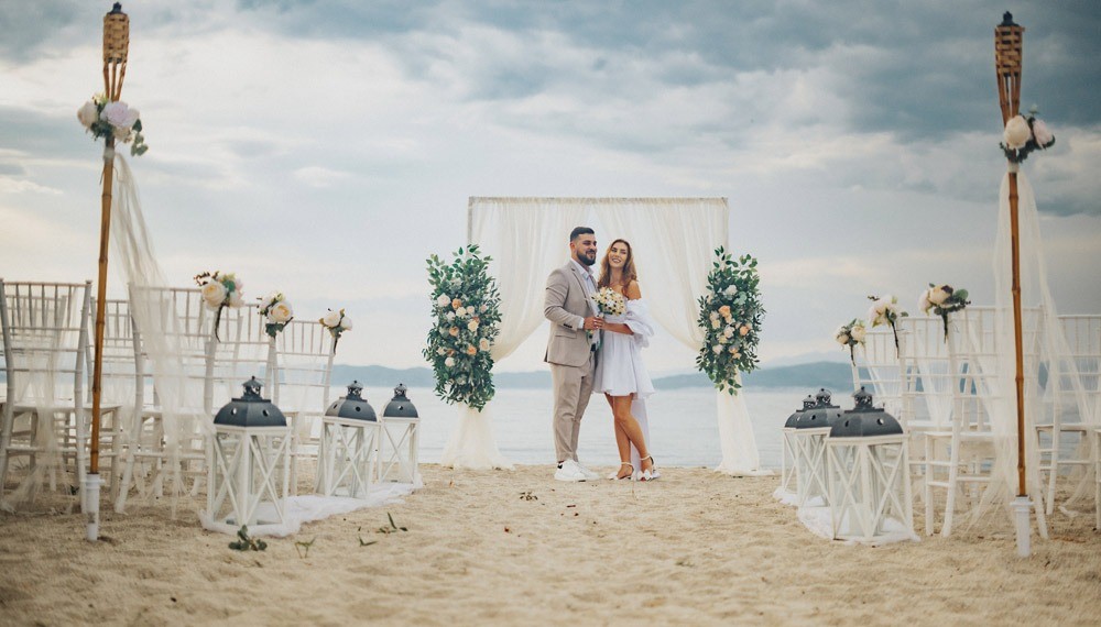 A beach wedding setting with arch and chairs, Nunta pe Plaja