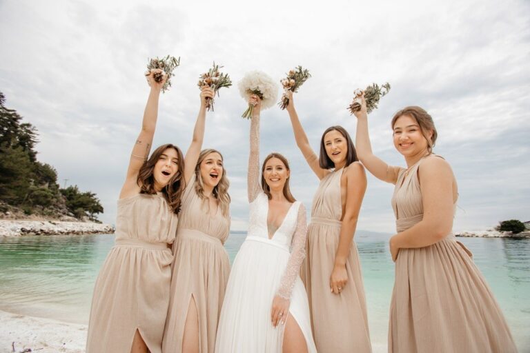 A bride and bridesmaids celebrating on a beach, Nunta pe Plaja