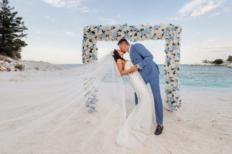 A couple kissing in front of a floral frame on a white beach, Nunta pe Plaja