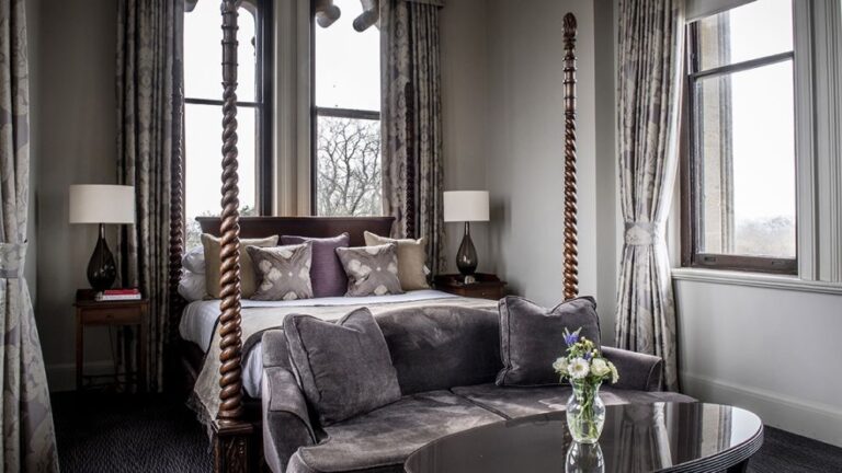 A bedroom with a barley-twist four-poster and views over the grounds, Nutfield Priory Hotel & Spa