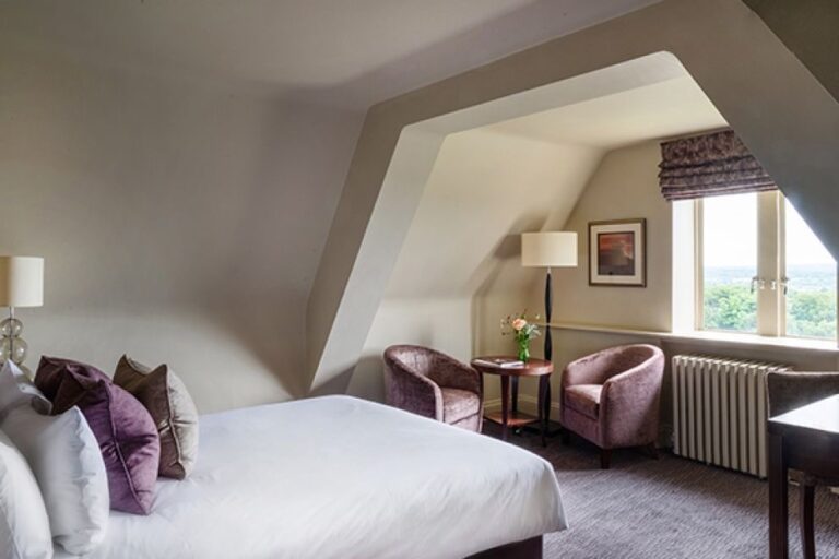 A Cosy Classic bedroom beneath the eaves, armchairs by the window, Nutfield Priory Hotel & Spa