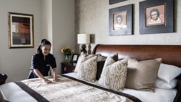 Turndown in a bedroom hung with antique portraits, Nutfield Priory Hotel & Spa