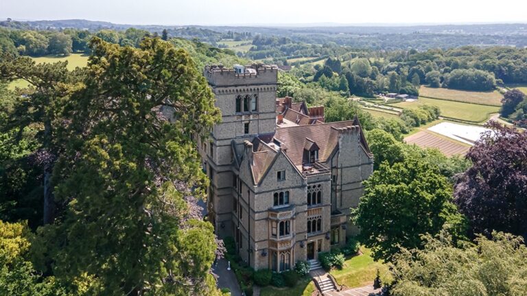 The mansion's Gothic tower rising above the trees, the Surrey and Sussex countryside beyond, Nutfield Priory Hotel & Spa