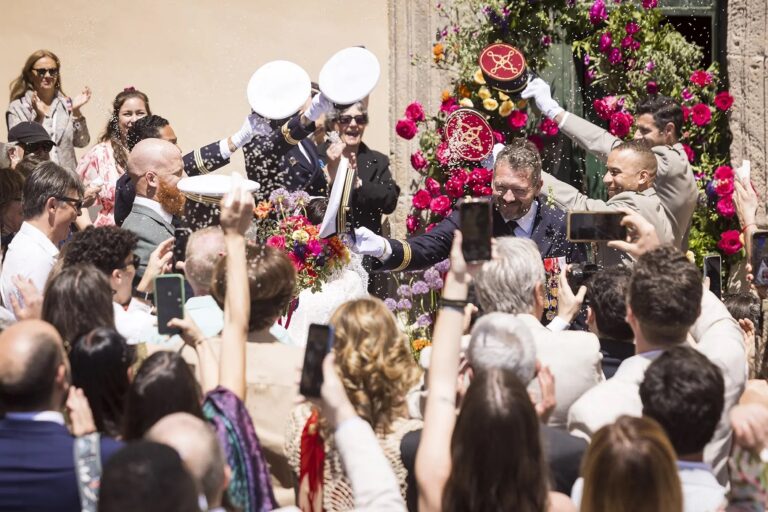 Confetti and drums at a church door hung with fuchsia and orange, O'Sarracino Events
