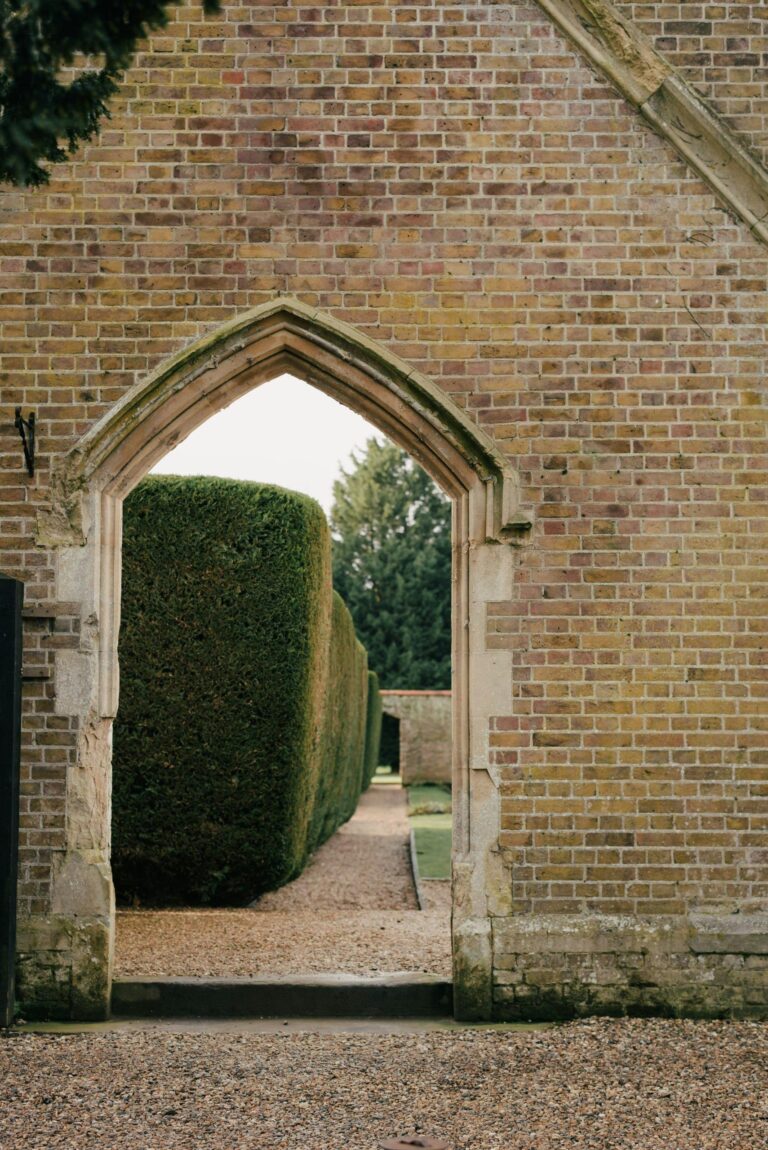 A Gothic brick archway framing a clipped hedge, Oakley Court Hotel, Windsor