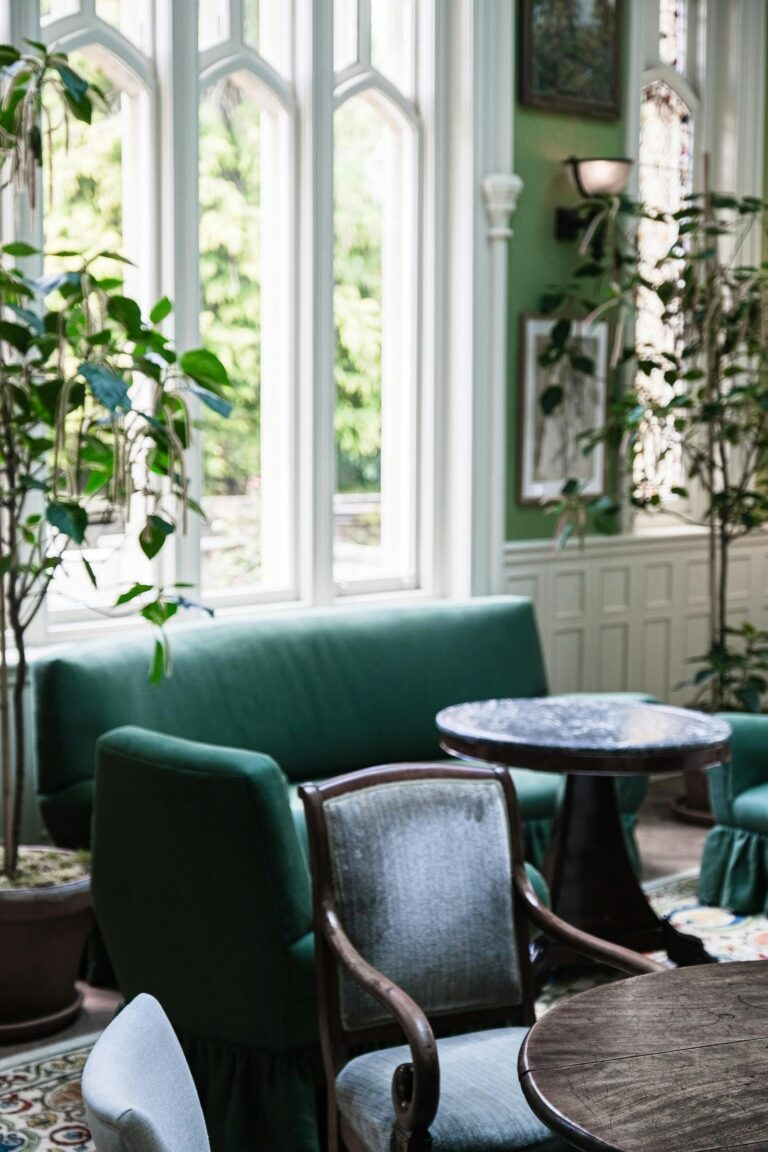 Green velvet seating beside tall Gothic windows, Oakley Court Hotel, Windsor