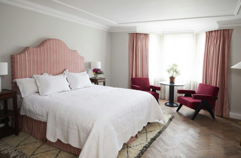 A bedroom with a pink striped headboard and bay window, Oakley Court Hotel, Windsor