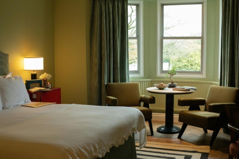 A bedroom with a green sitting area and garden views, Oakley Court Hotel, Windsor