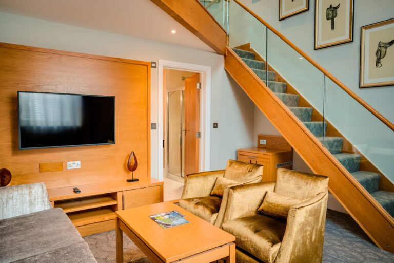 The lounge of a split-level Courtyard Suite, with a staircase up to the bedroom, Oakley Hall Hotel