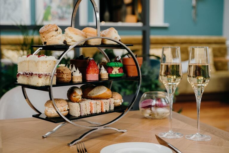 Afternoon tea on a tiered stand with two flutes of fizz in the Glasshouse Restaurant, Oakley Hall Hotel