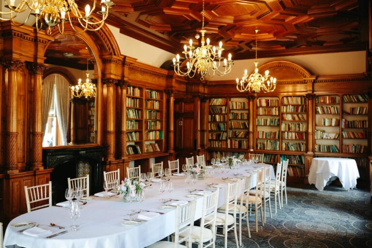 The Library laid for a wedding breakfast beneath gilt chandeliers and a coffered timber ceiling, Oakley Hall Hotel