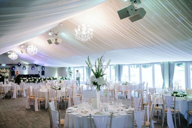 The Garden Pavilion set with round tables under a draped ceiling and chandeliers, Oakley Hall Hotel