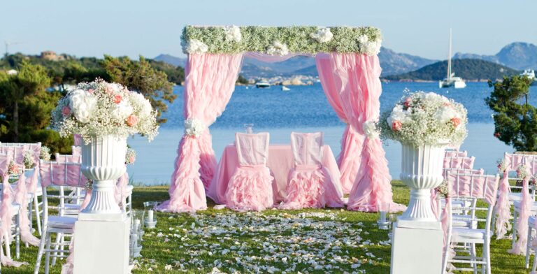 Garden ceremony by the sea with blush draping and white urns of flowers, Costa Smeralda, Oggi Sposi & Events