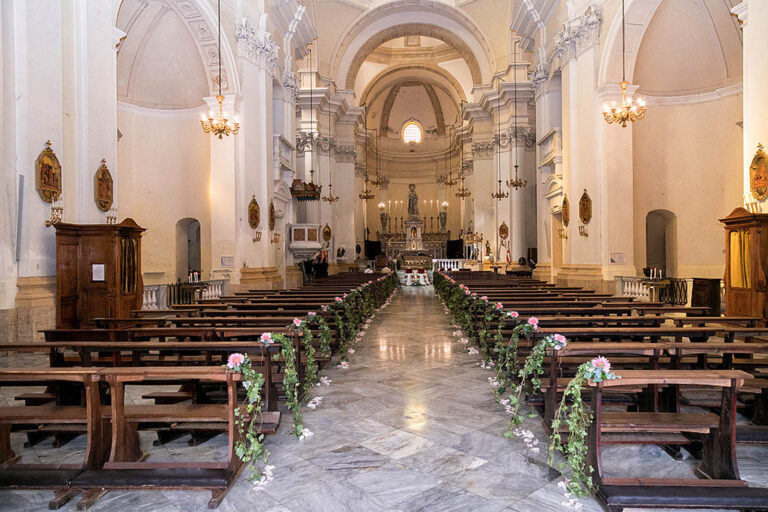 Church aisle with garlands of greenery and white flowers on the pews, Oggi Sposi & Events