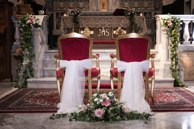 Red and gold bride and groom chairs dressed in tulle before the altar, Oggi Sposi & Events