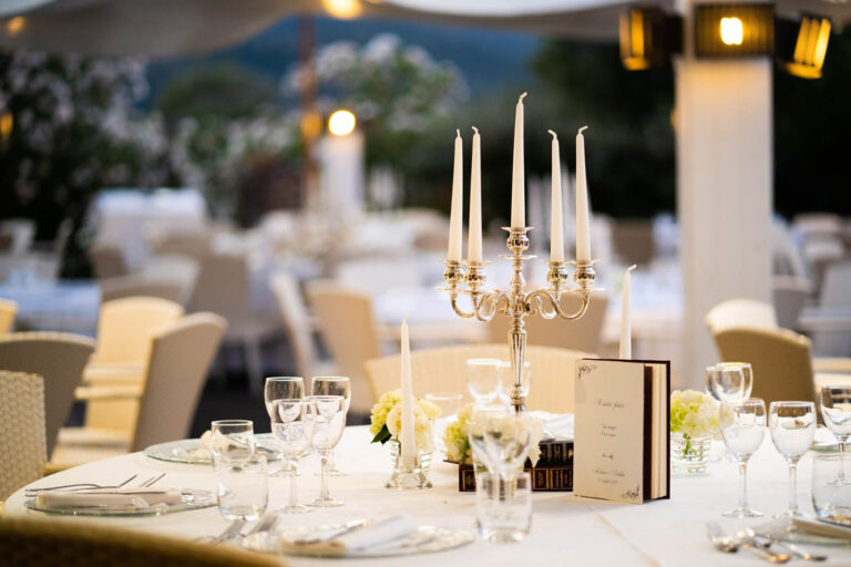 Reception table with silver candelabra, crystal and a menu card, set outdoors, Oggi Sposi & Events