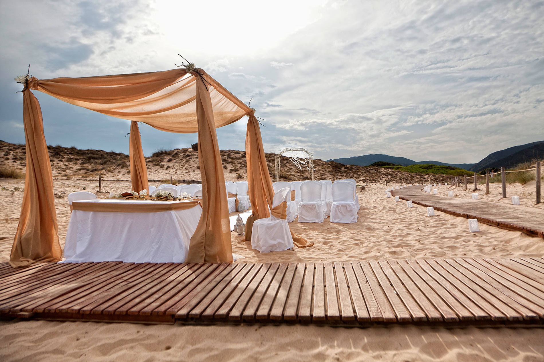 Draped gazebo and tables on a boardwalk over the sand, Chia, Oggi Sposi & Events