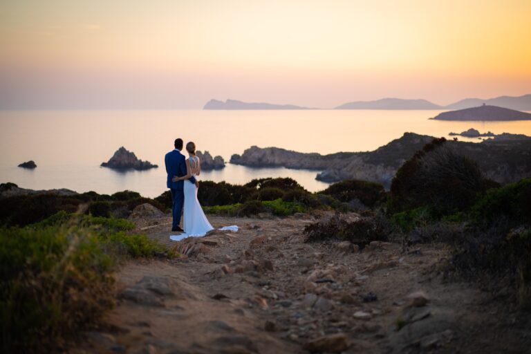 Couple on a rocky headland above the sea at sunset, Sardinia, Oggi Sposi & Events