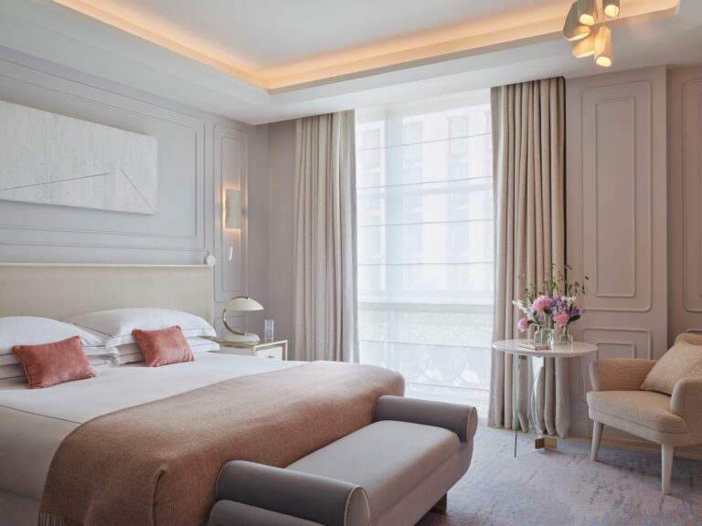 A Superior bedroom in pale panelling with a bench at the foot of the bed, One Aldwych