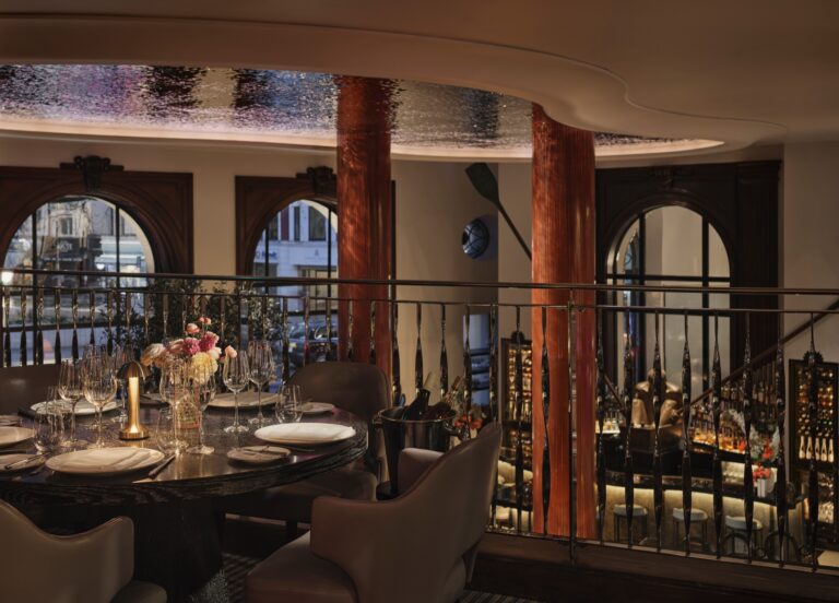 A table on the Indigo mezzanine looking down over the Lobby Bar and out through the arched windows, One Aldwych