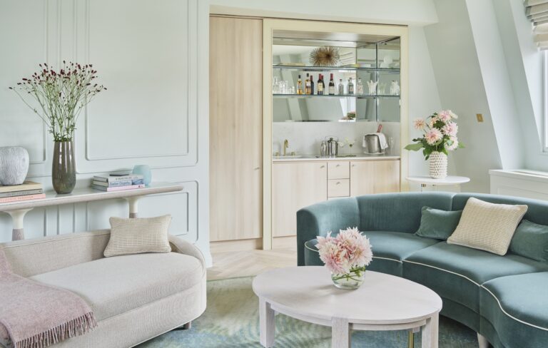 The living room of the Terrace Suite, with a curved velvet sofa and a bar niche, One Aldwych