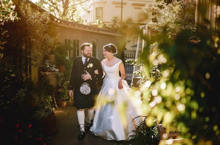 The bride and groom walking through the greenery-lined garden terrace at golden hour, One Marylebone