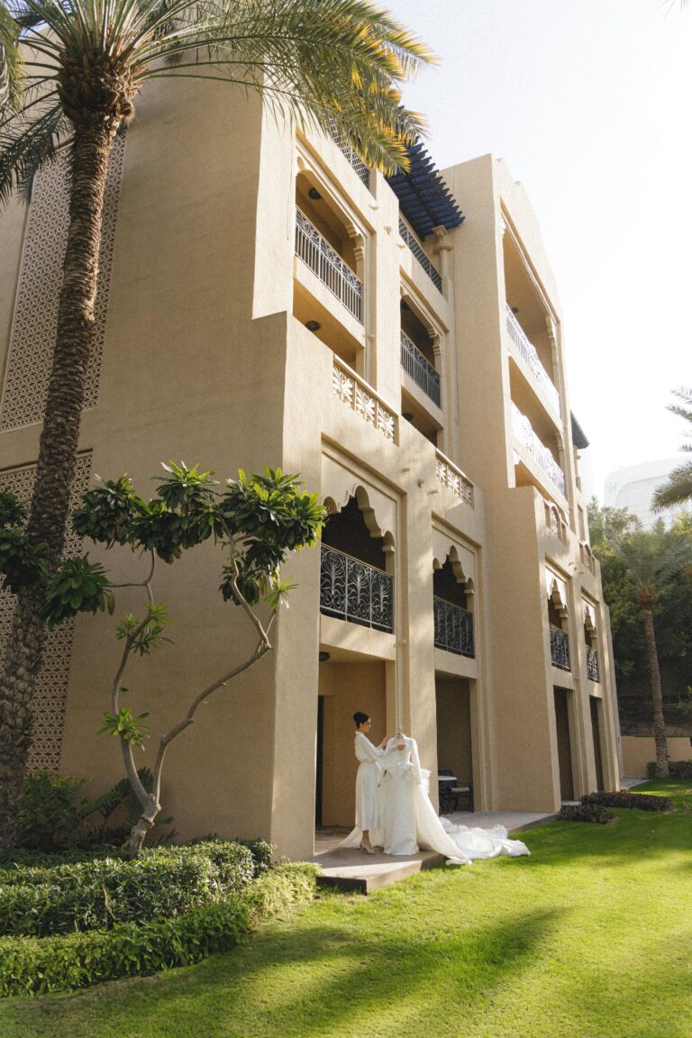A bride on the lawn beside an Arabian Court building, One&Only Royal Mirage