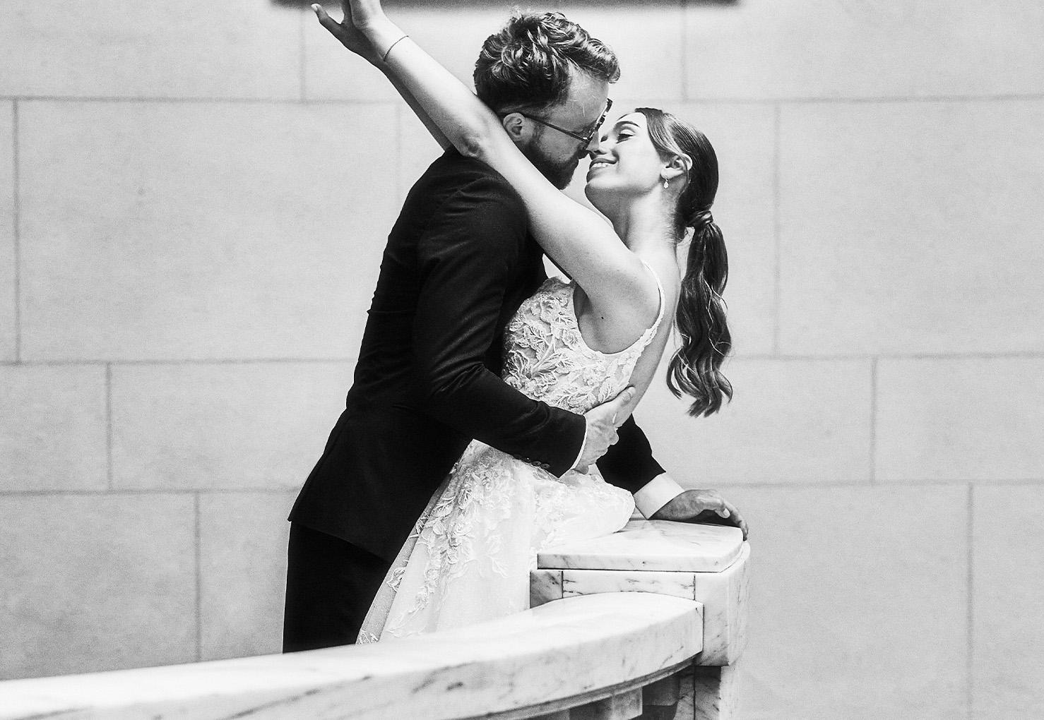 A couple embracing on the marble staircase, in black and white, One Whitehall Place