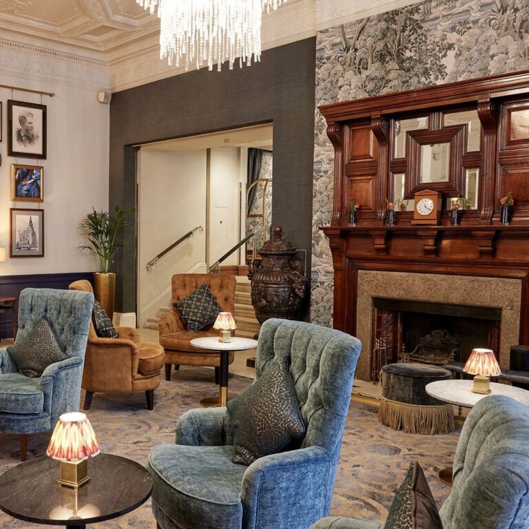The lobby with a stone fireplace and armchairs, One Whitehall Place