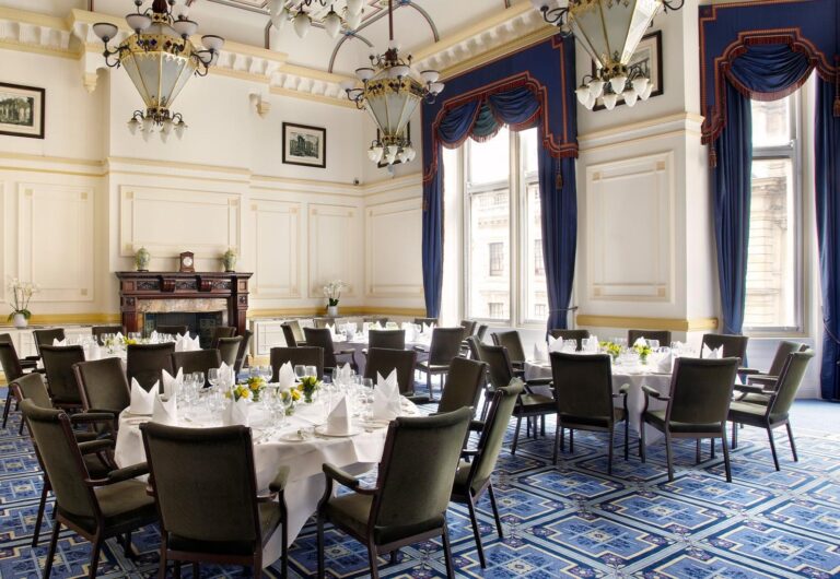 The Meston Suite laid with round tables beneath tall windows, One Whitehall Place
