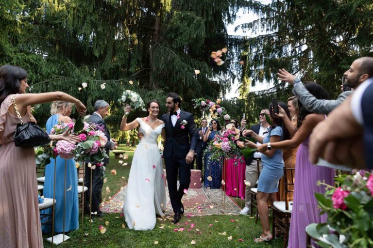 Guests throwing petals as Caterina and Rashed walk out of their garden ceremony, Villa Semenza, Ordine della Giarrettiera
