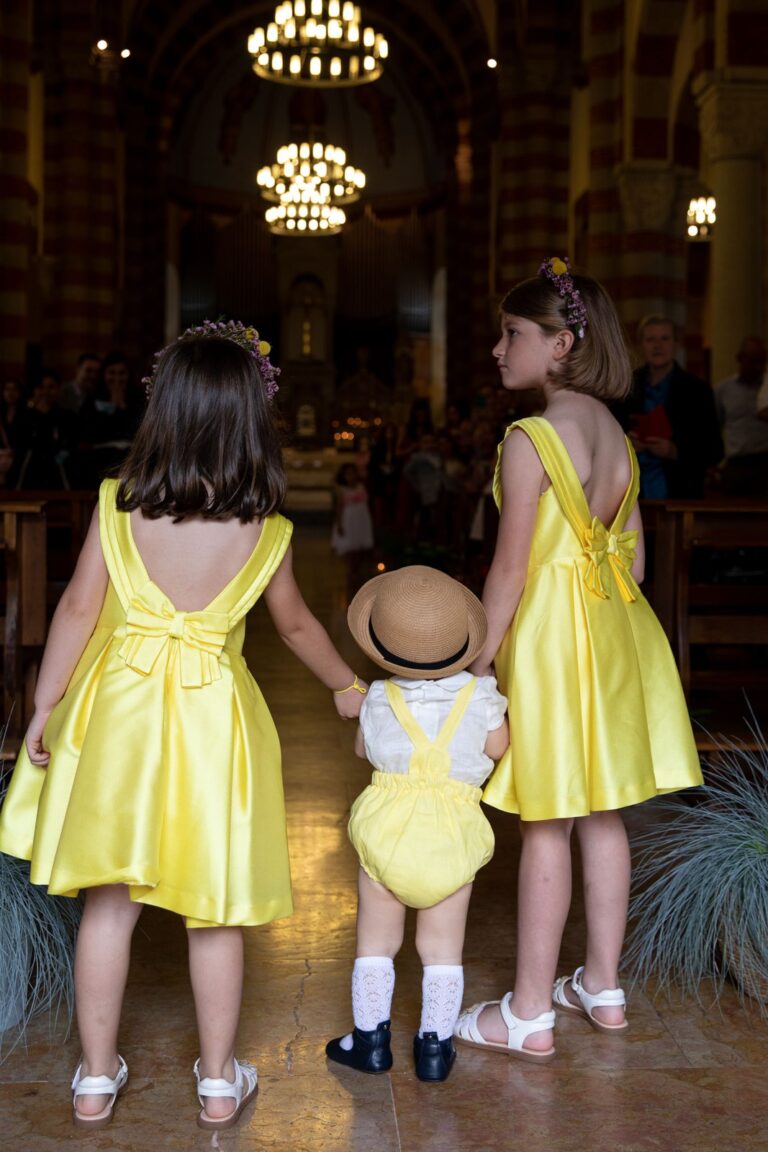 Three young guests in yellow hand in hand in the church, a ceremony in Brera, Milan, Ordine della Giarrettiera