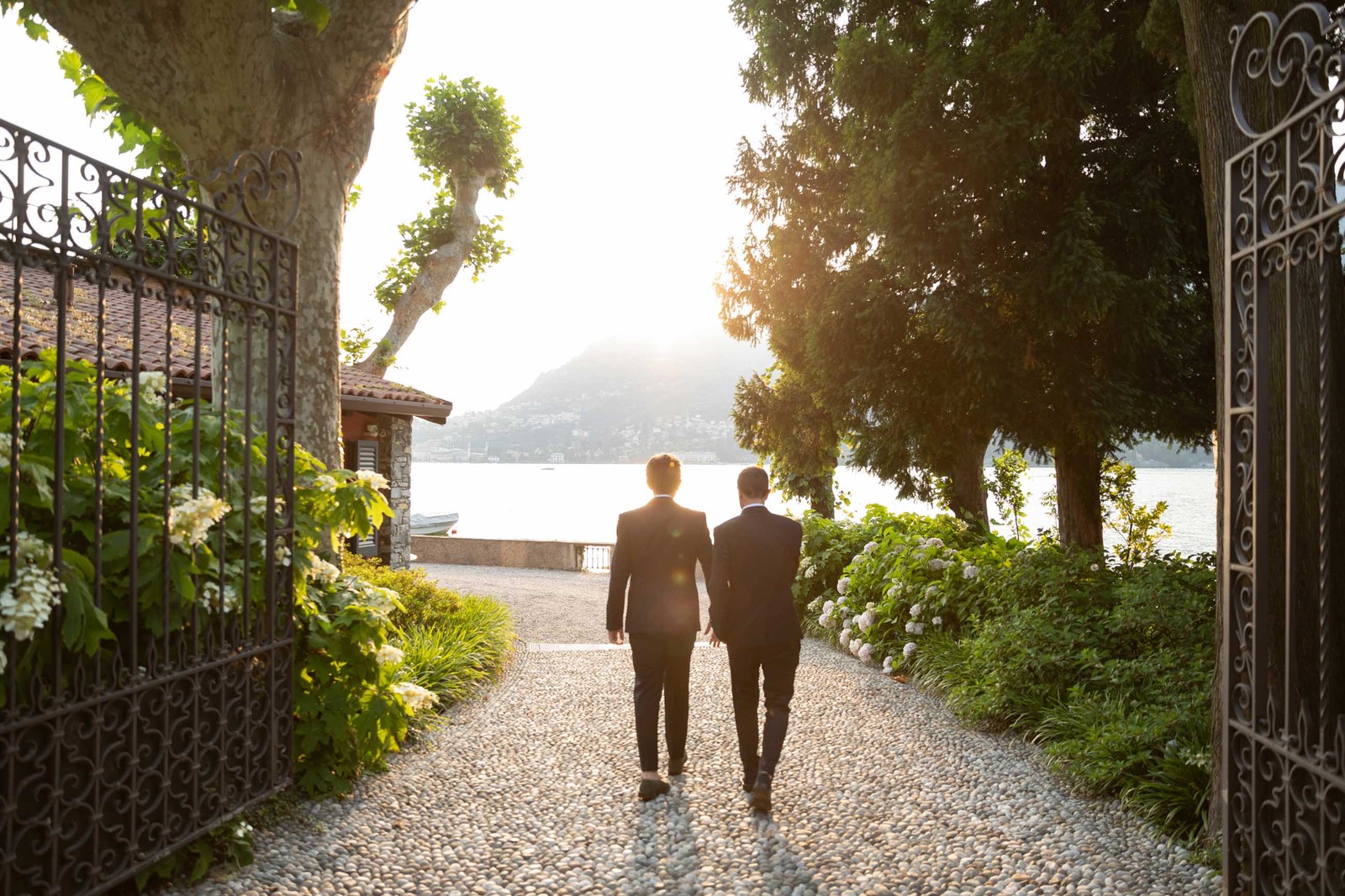 Two grooms walking a lakeside avenue at sunset, a civil union on Lake Como, Ordine della Giarrettiera