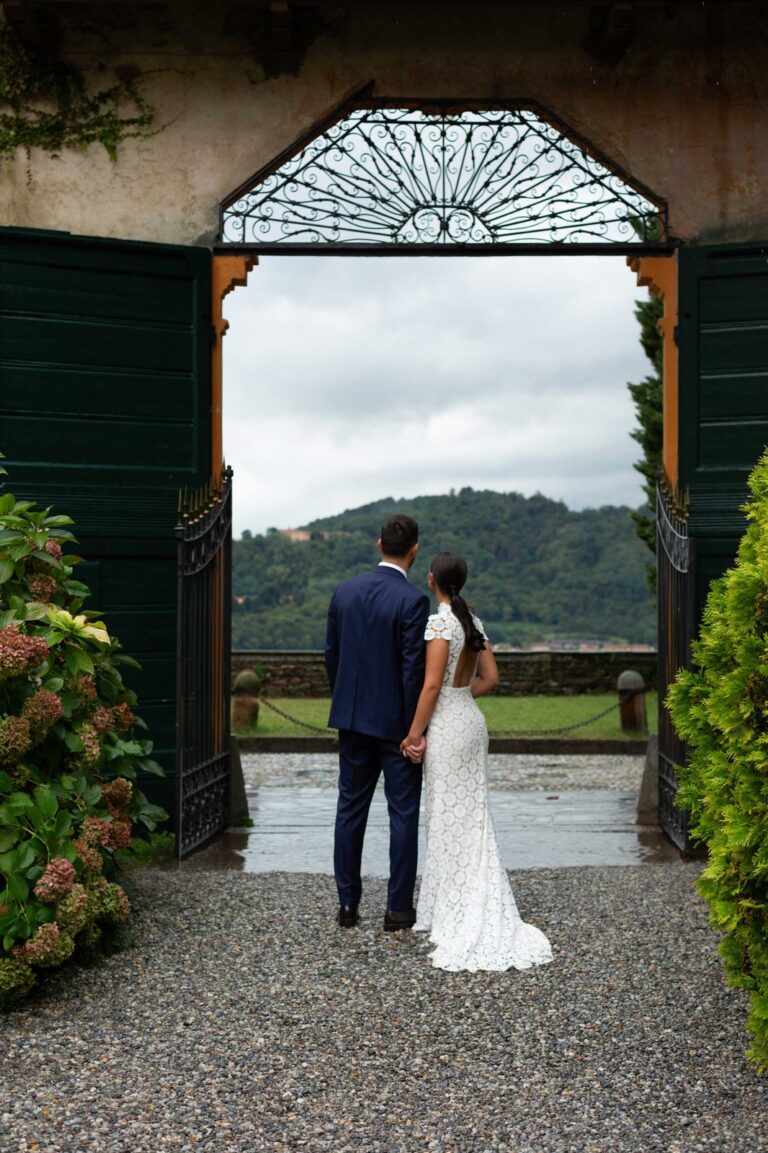 Bride and groom looking out through the gateway over the hills, Villa Semenza, Ordine della Giarrettiera