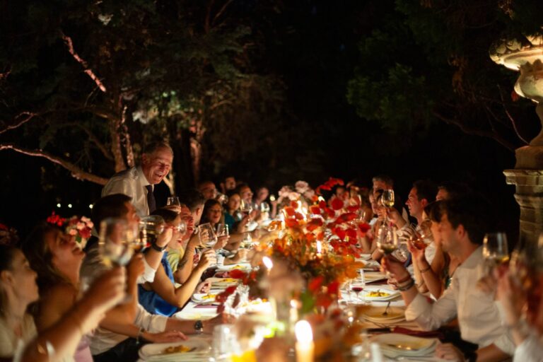Guests raising glasses at a long candlelit table in the garden of Villa Clerici, Milan, Ordine della Giarrettiera