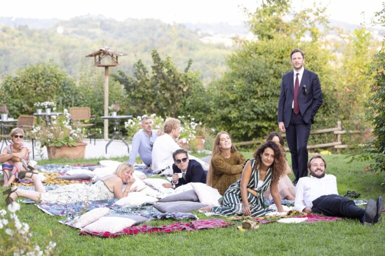 Guests relaxing on rugs and cushions on the grass after a civil union at Ca' Mariuccia, Monferrato, Ordine della Giarrettiera
