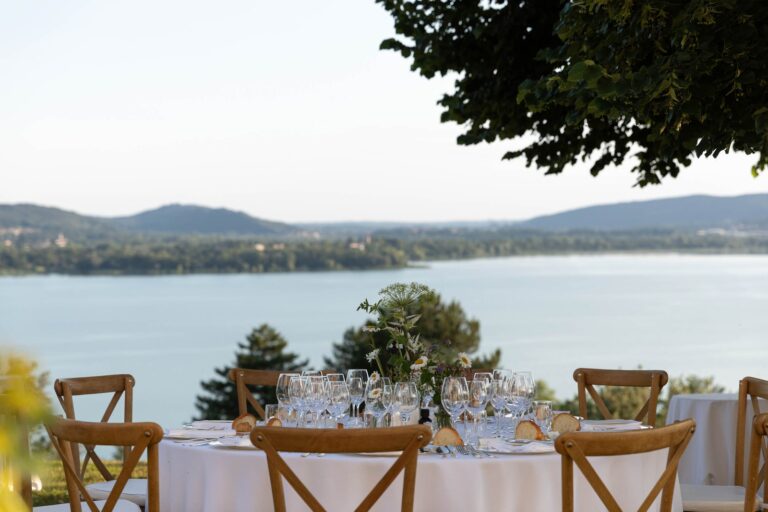 A table laid on a terrace above the lake, the hills beyond, at E&M's lakeside wedding, Ordine della Giarrettiera