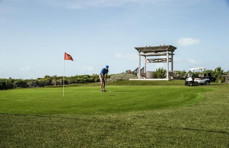 Golfer on a green beside the pavilion, Over Yonder Cay