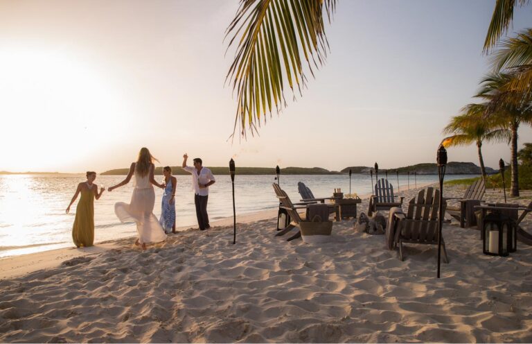 Guests gathering on the beach at sunset, Over Yonder Cay