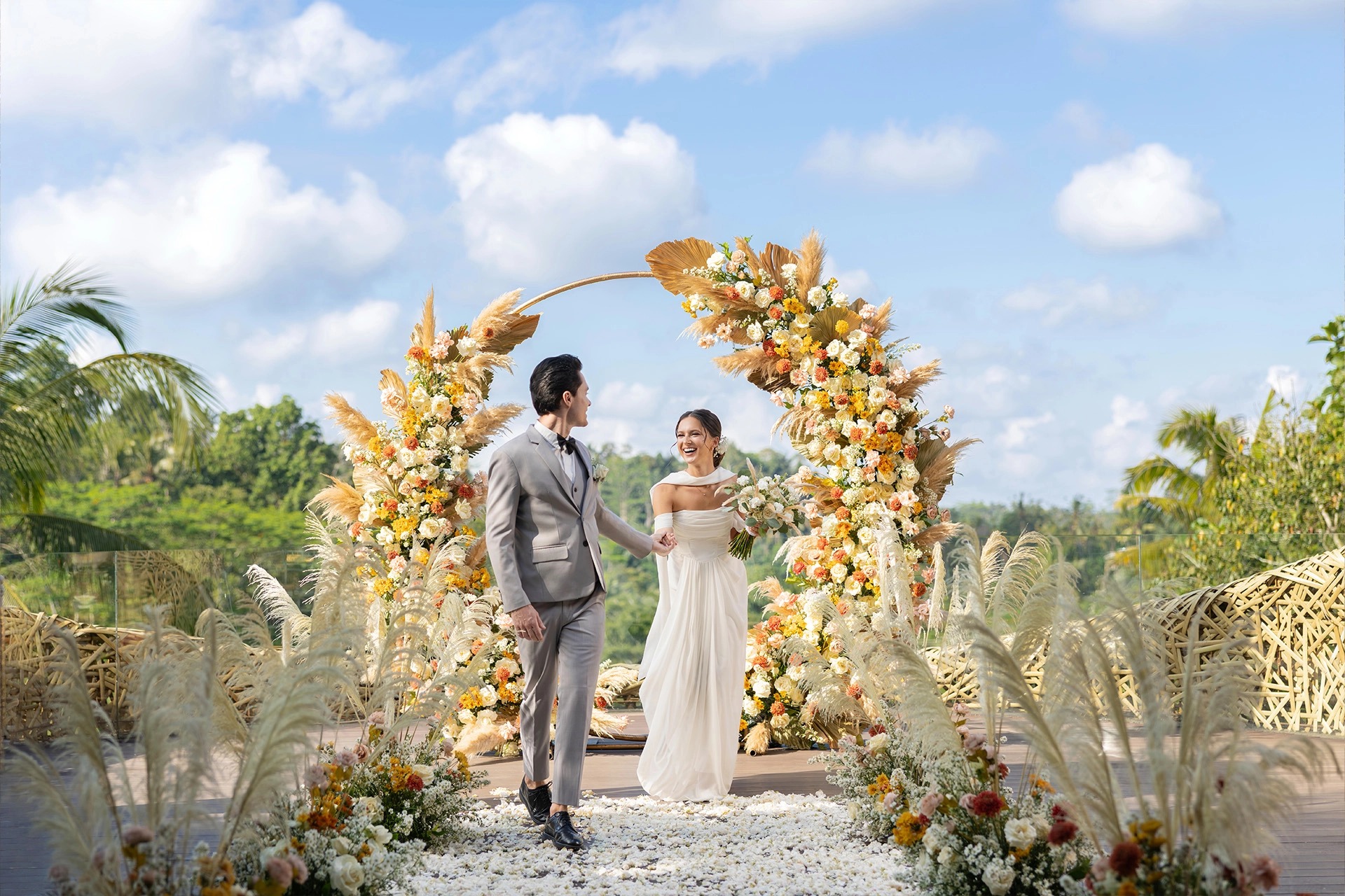 A couple beneath a floral arch at the Bamboo Nest, Padma Resort Ubud
