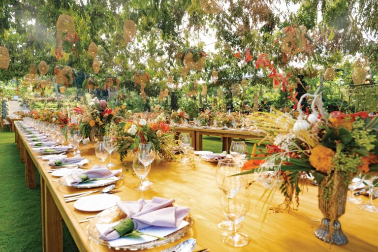 Long reception table with floral centrepieces on the lawn, Padma Resort Ubud